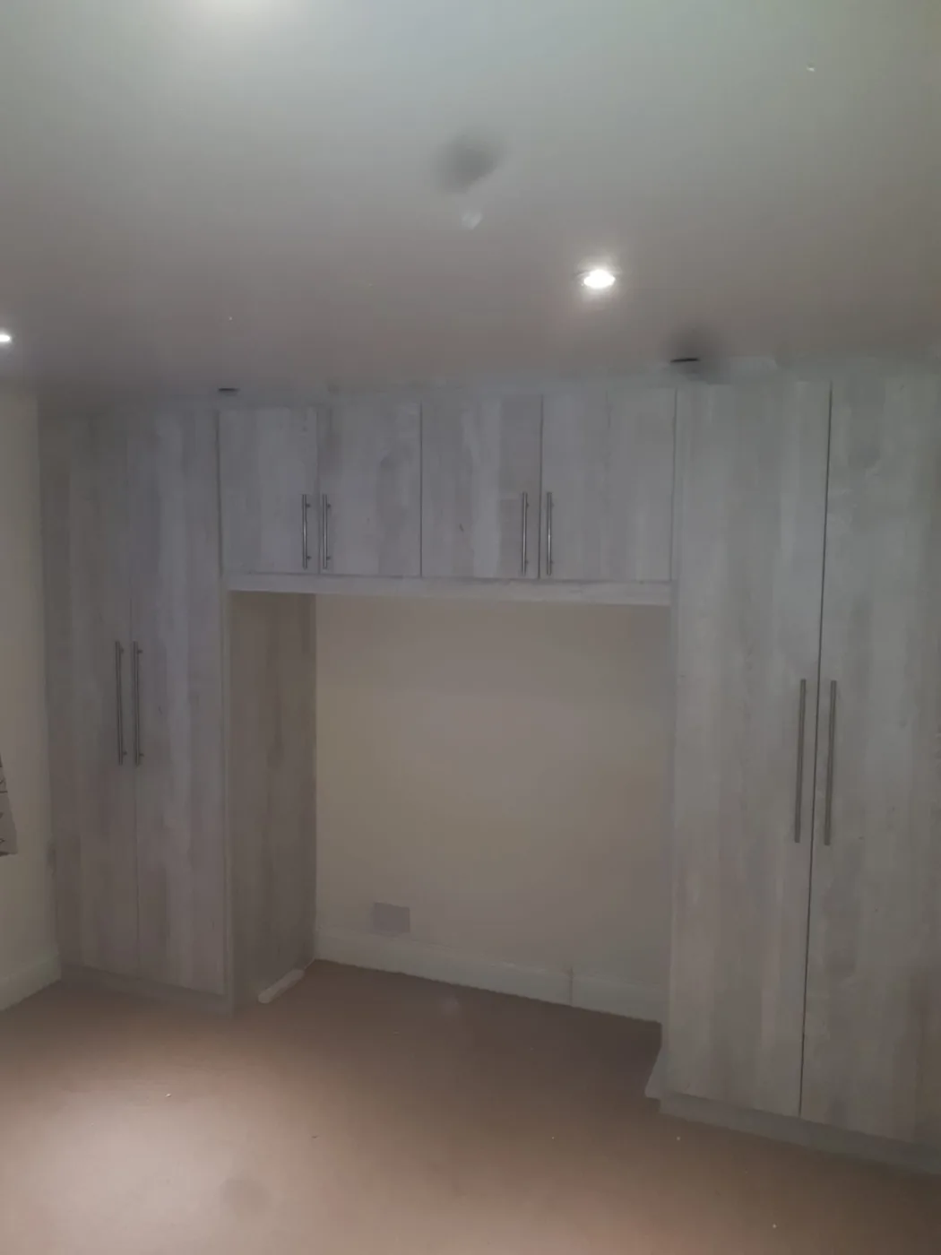 Light oak-effect overbed wardrobe surround