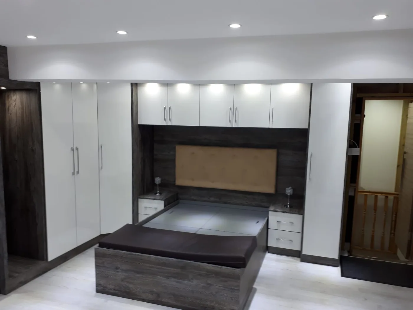 White gloss overbed wardrobes · dark wood headboard nook
