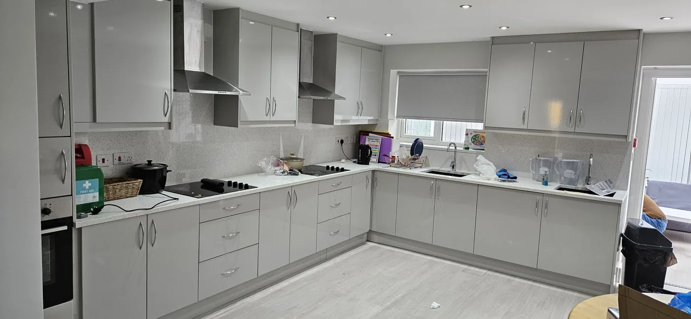Light grey gloss L-shape kitchen · white worktop