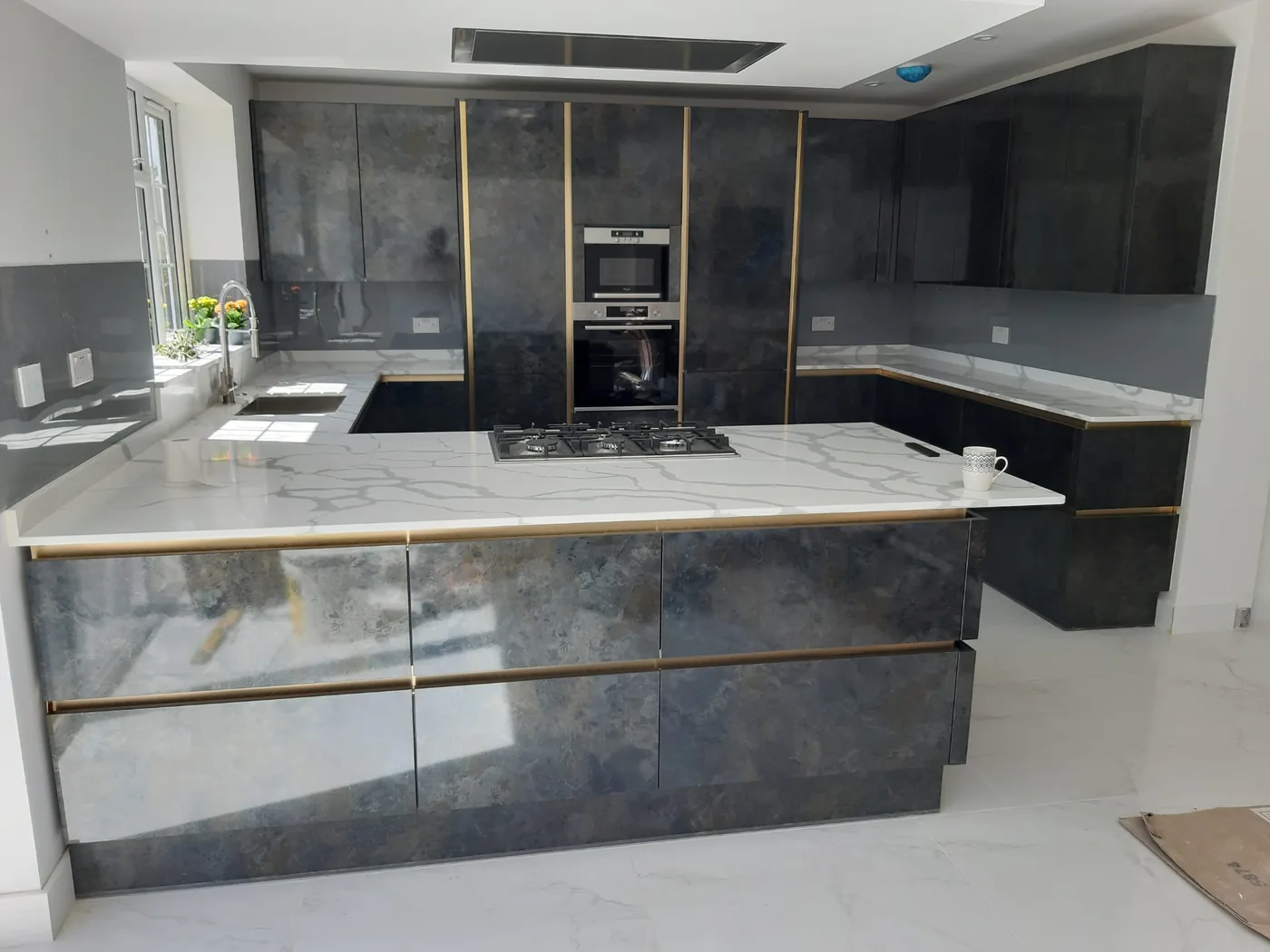 Graphite stone-effect island kitchen · brass trim