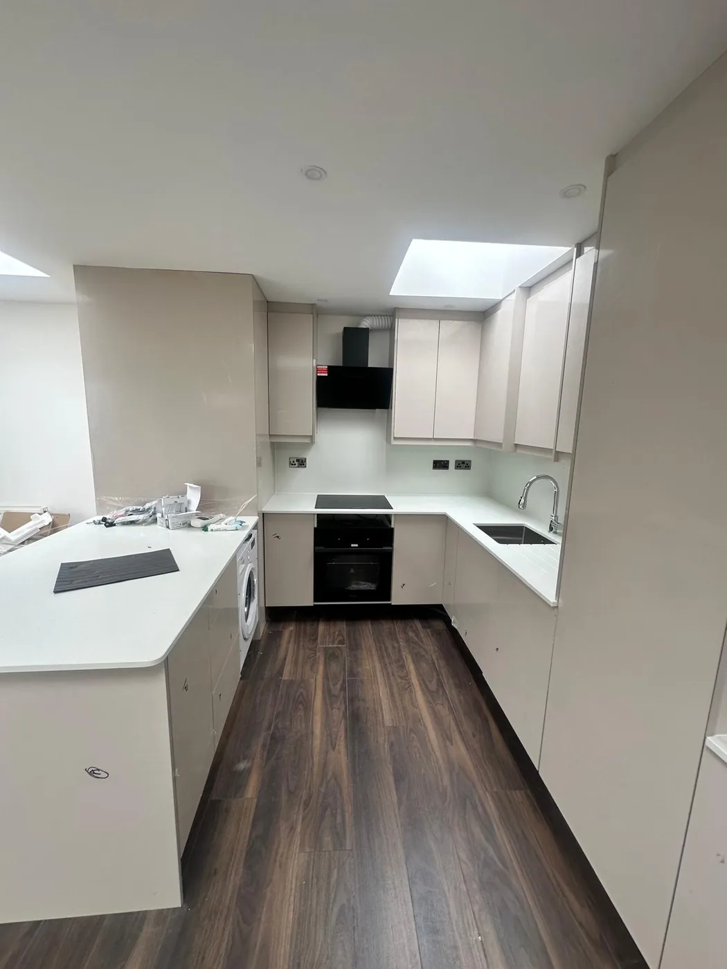 Cream gloss U-shape kitchen · black extractor & oven