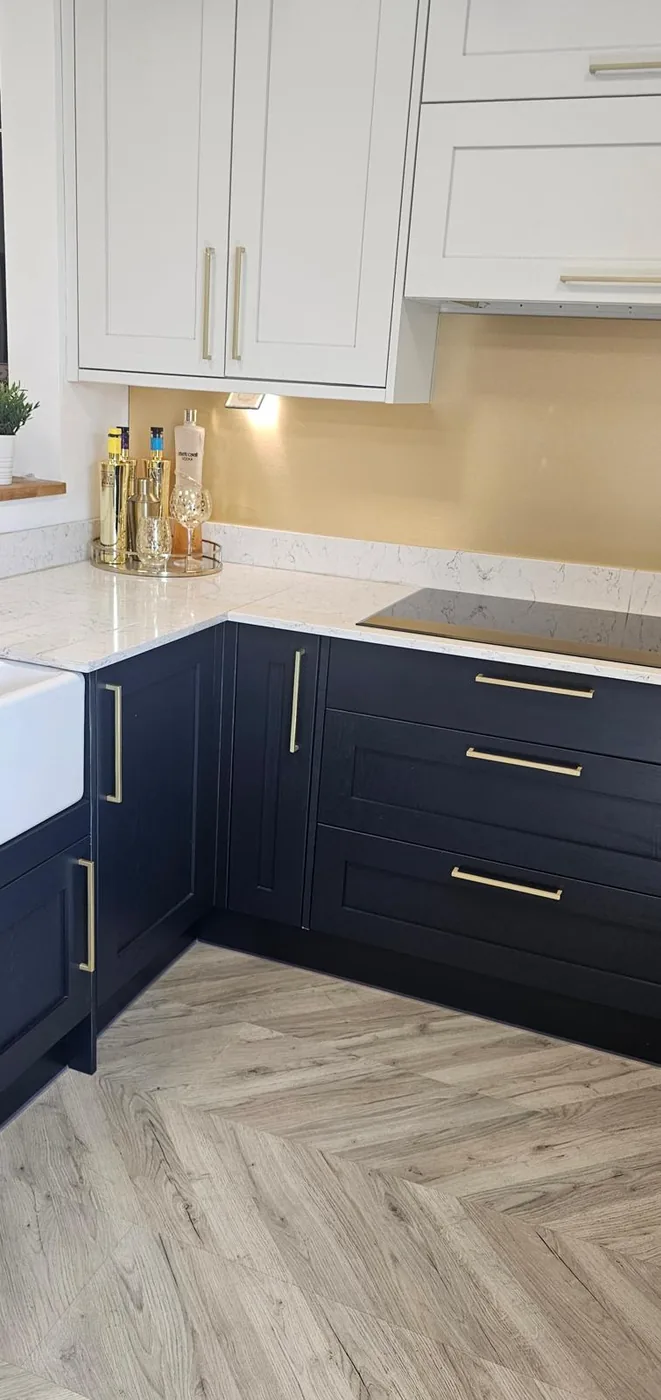 Navy shaker corner kitchen · brass handles · herringbone floor