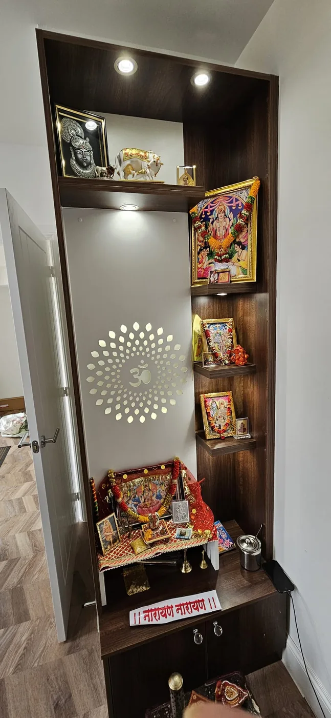 Walnut mandir tower · backlit Om · deity idols & photos