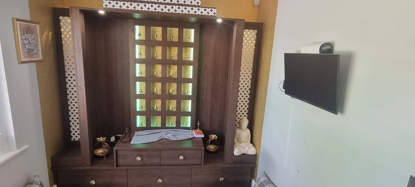 Walnut mandir cabinet · jaali fretwork · backlit bell grid
