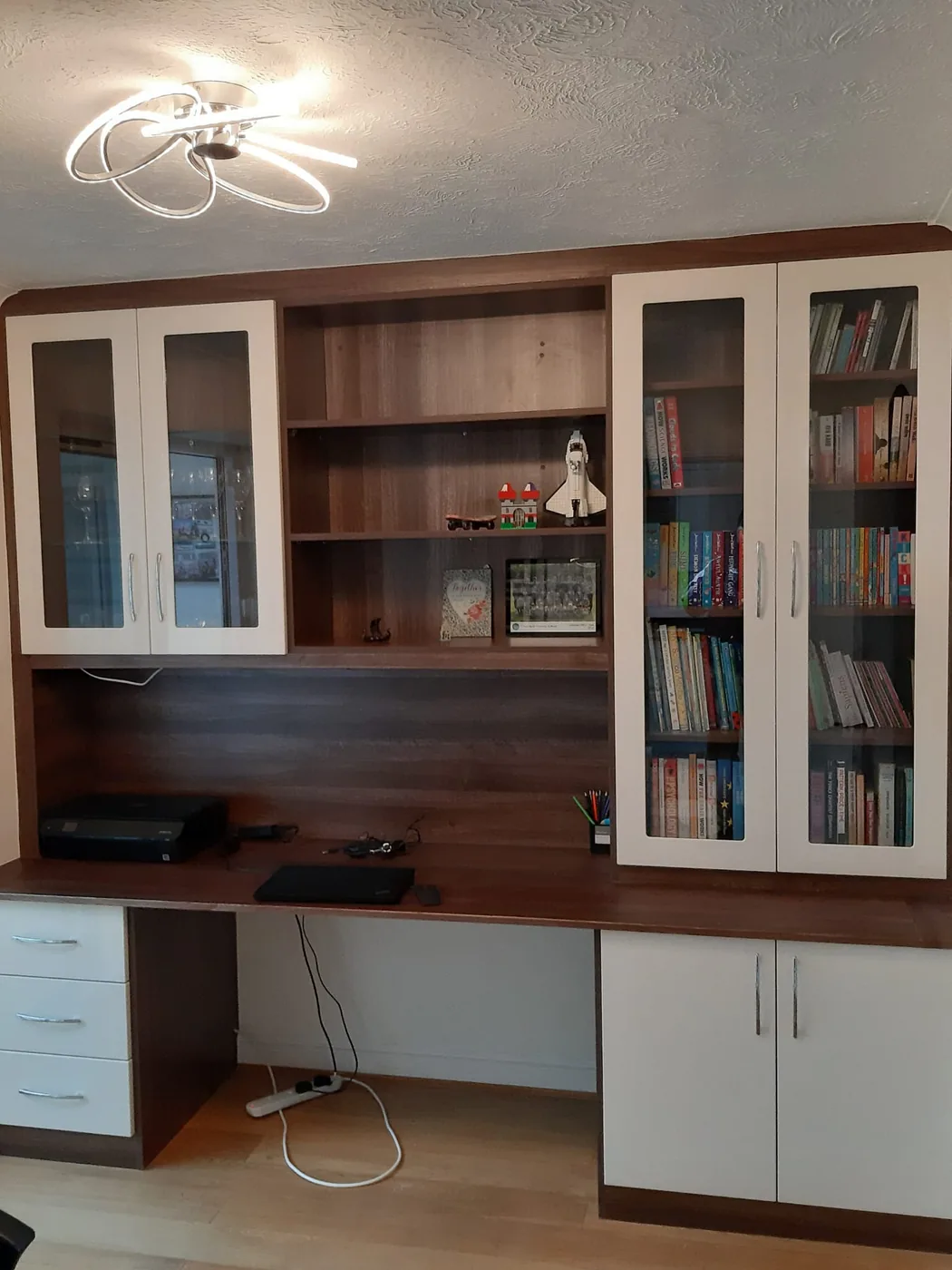 Walnut desk & bookcase wall · glass-front cabinets · floating shelves