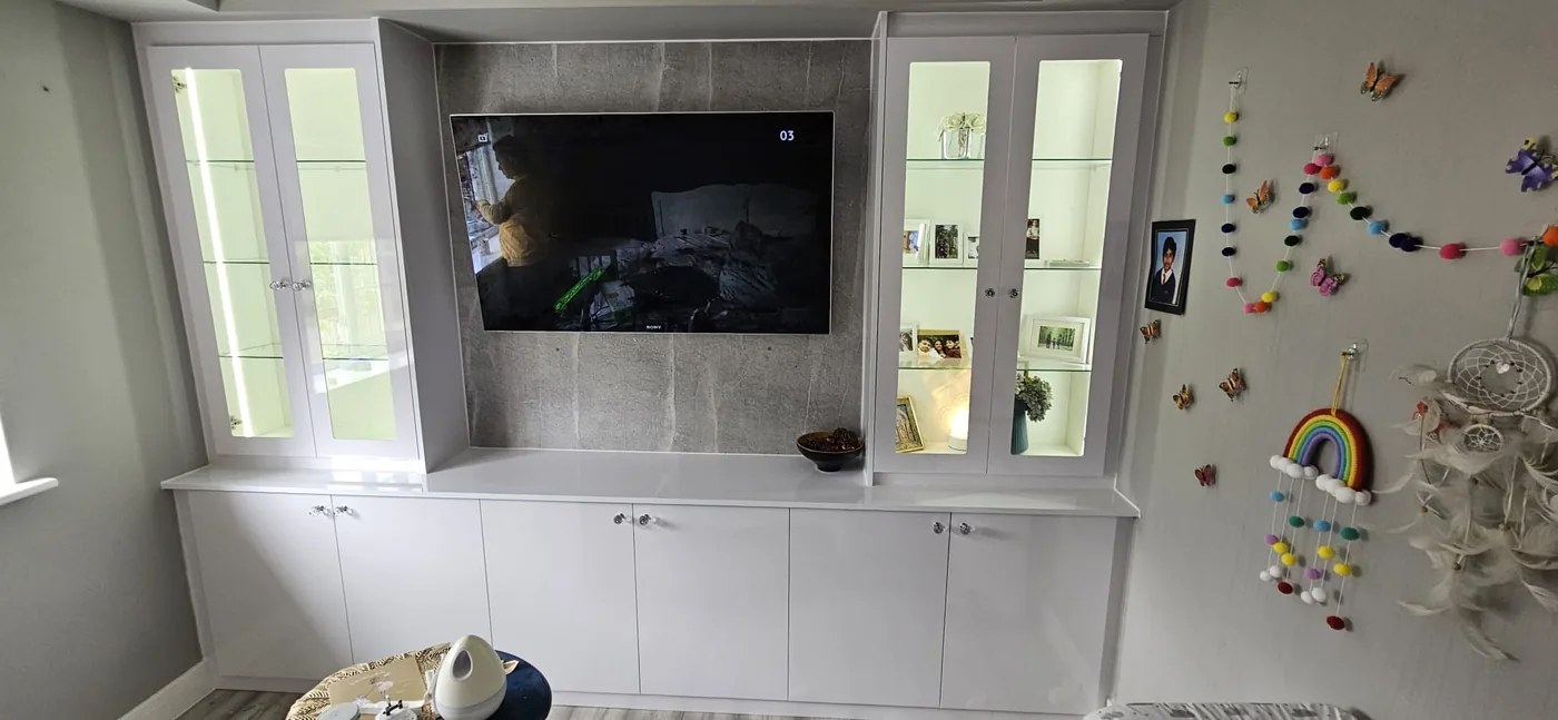 White gloss media unit · glass display cabinets either side