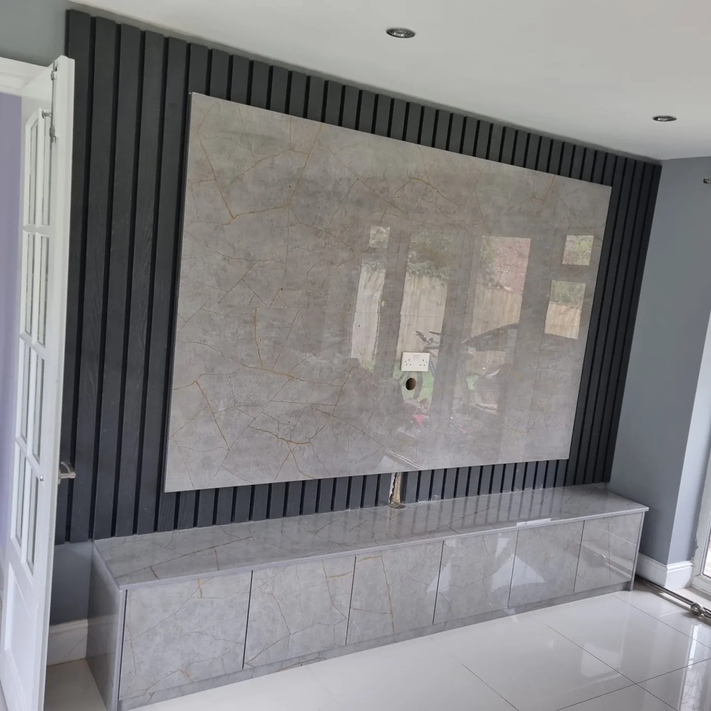 Grey crackle-marble media wall · floating cabinet