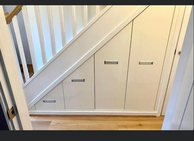 White gloss pull-out drawers · staircase storage