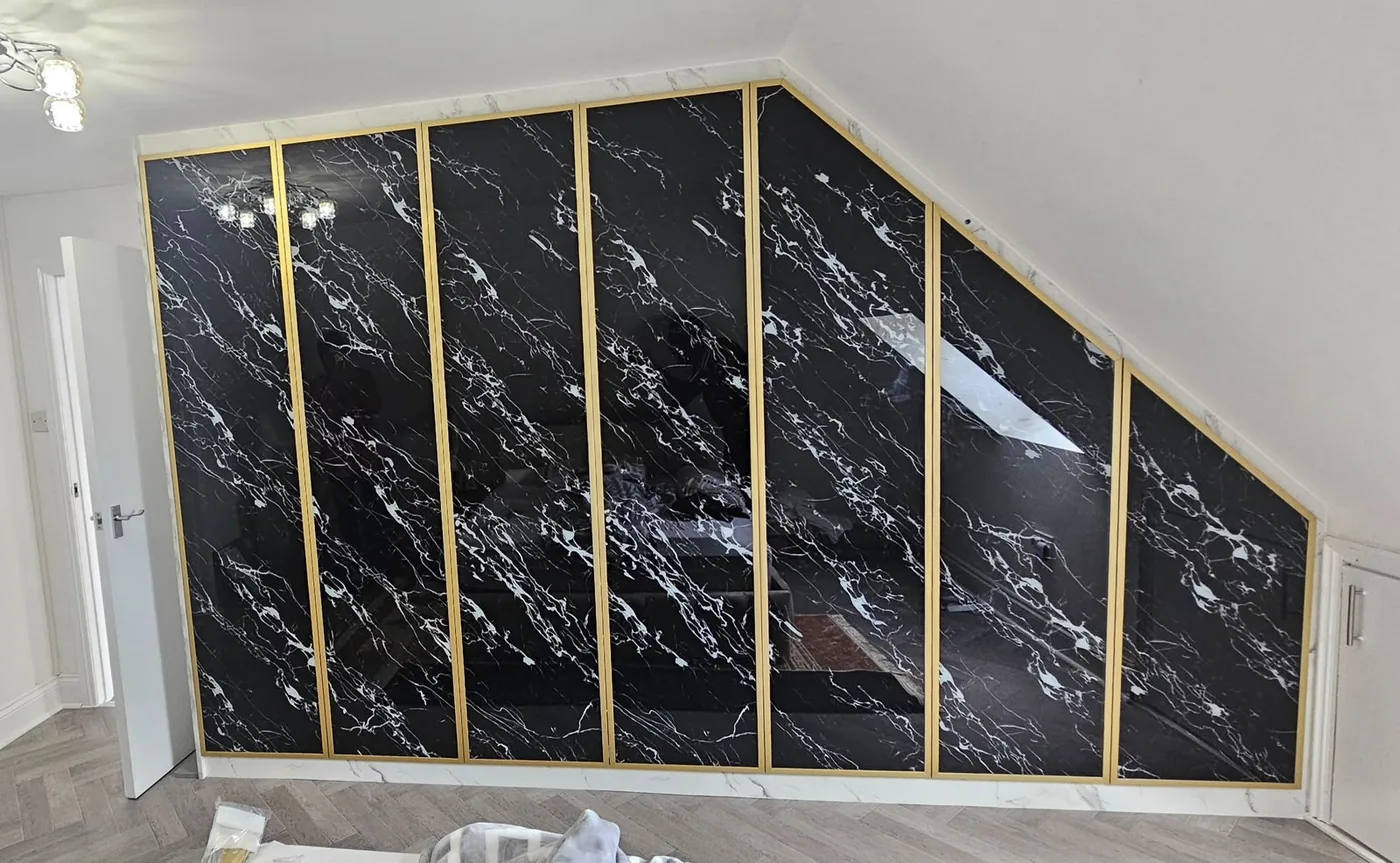 Black marble-effect loft wardrobe · brass trim