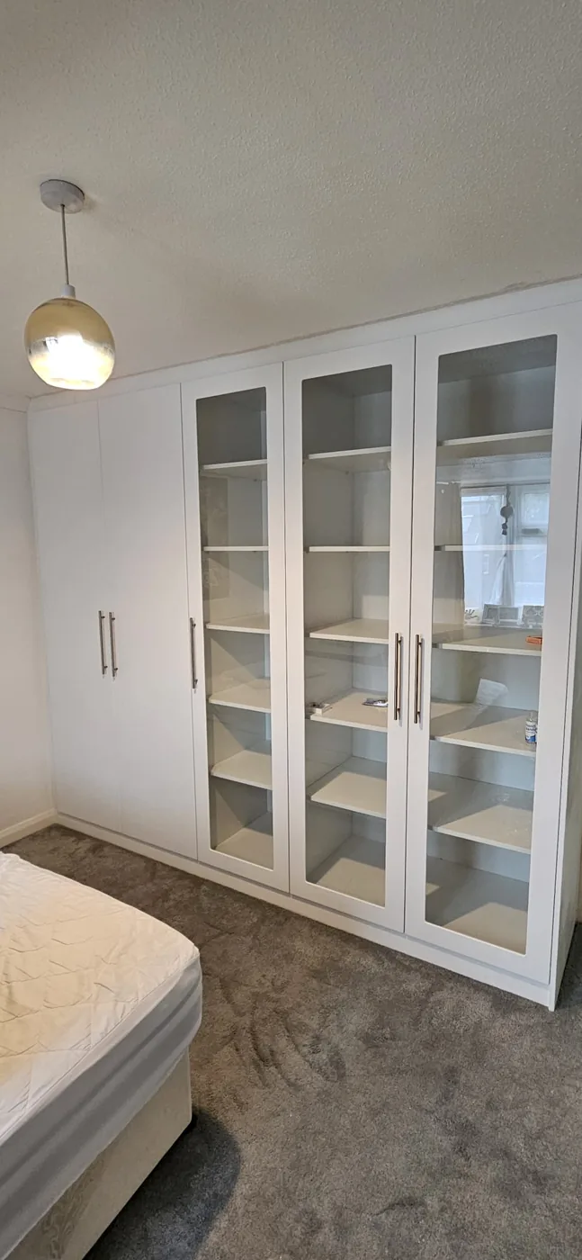 White wardrobe · glass-panel doors · chrome handles