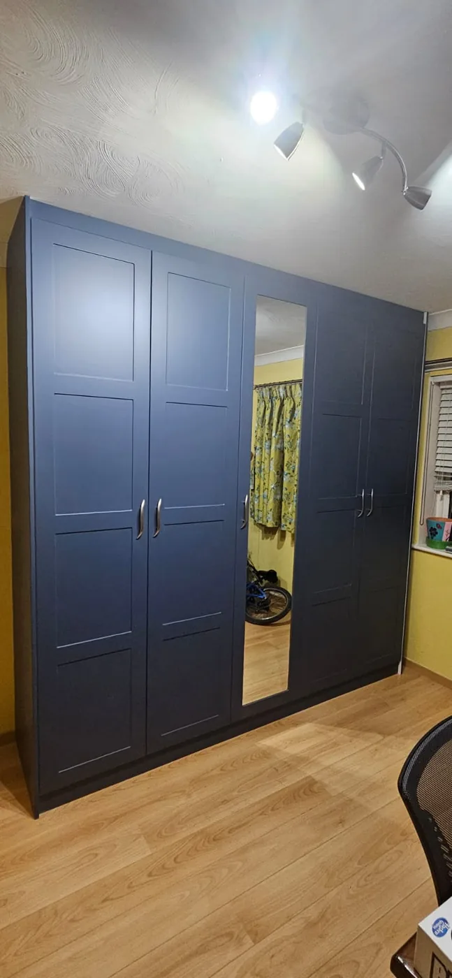Navy wardrobe · mirrored centre panel · chrome handles