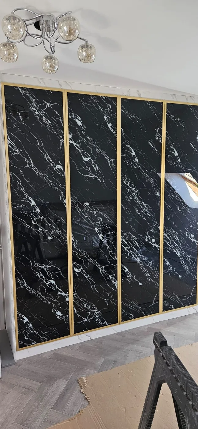 Black marble-effect wardrobe · gold trim