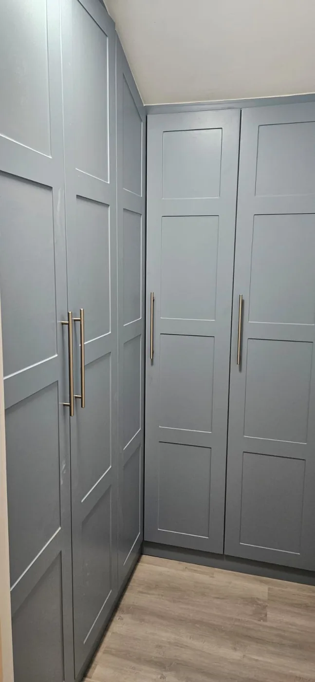 Slate-blue corner fitted wardrobe · brass handles
