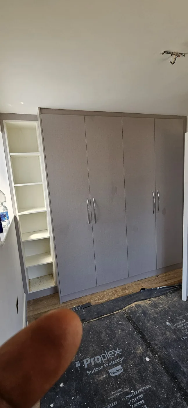 Grey fitted wardrobe · adjoining open shelving