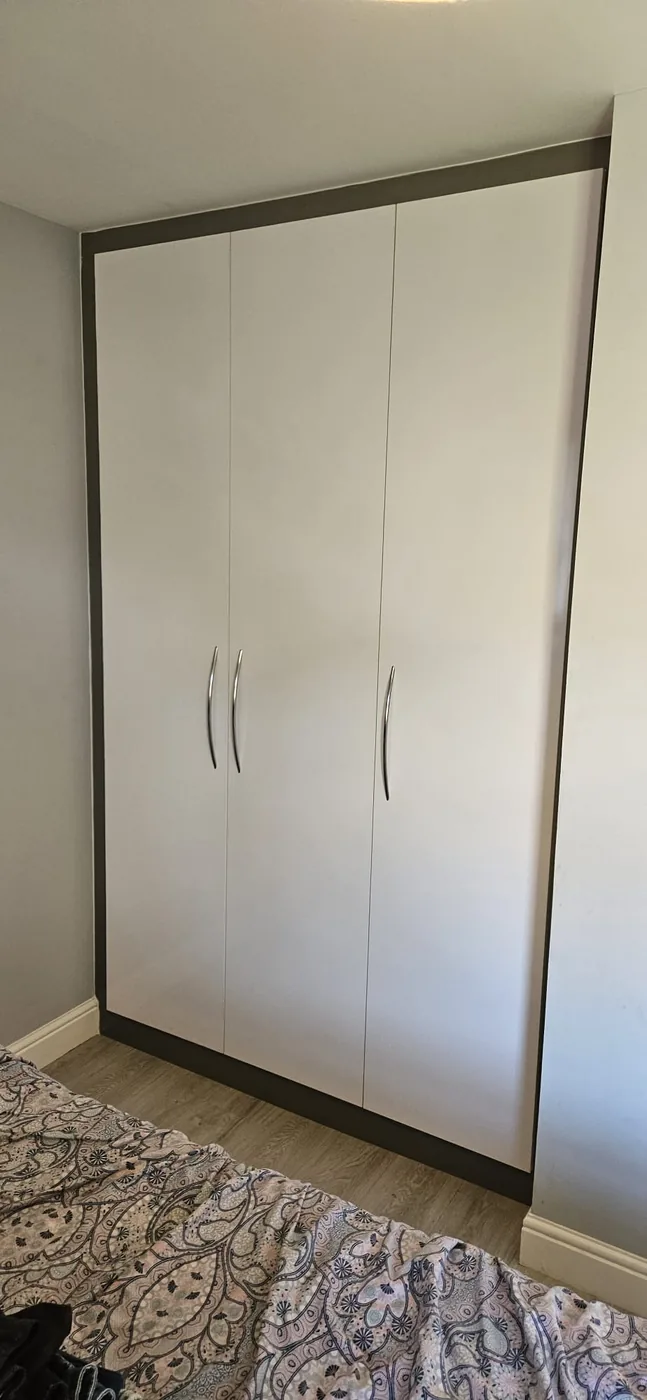 White wardrobe · bronze trim · curved handles
