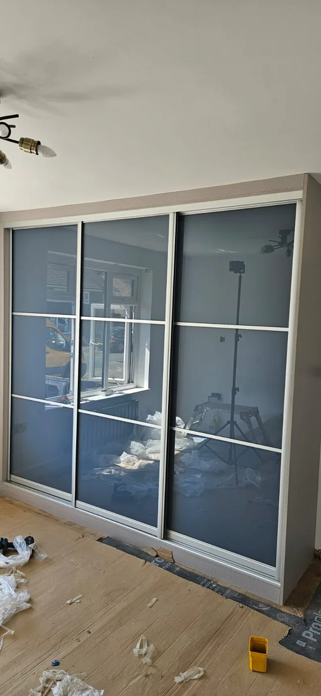 Full-wall mirrored sliding wardrobe · LED strip