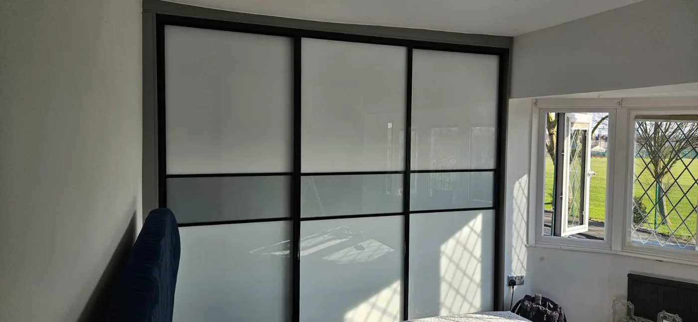 White frosted-glass sliding wardrobe · black frame