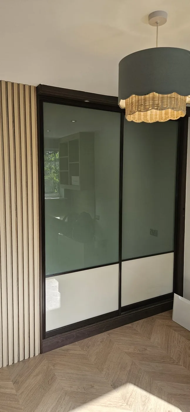 Sage green glass sliding wardrobe · oak slat surround