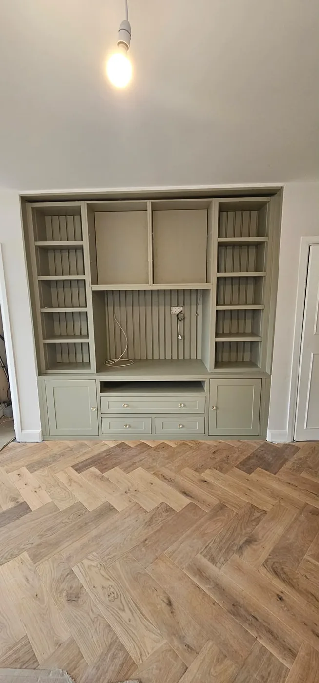 Sage green fitted alcove shelving & cabinet unit · herringbone floor